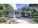 Charming single-story home features a covered carport and quaint front porch with red accents at 406 Zoller St, Brooksville, FL 34601