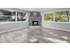 Spacious living room with a decorative stone fireplace, large windows and light wood flooring at 406 Zoller St, Brooksville, FL 34601
