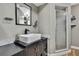 Modern bathroom with a rectangular basin sink, walk-in shower and black hardware at 4206 Candler Ave, Spring Hill, FL 34609