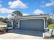 Attached two-car garage with a blue door complements this well-maintained single-story home at 4206 Candler Ave, Spring Hill, FL 34609