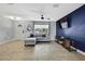 Bright living room with a sofa near the front door and a blue decorative accent wall with TV at 4206 Candler Ave, Spring Hill, FL 34609