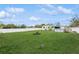 Large grassy backyard enclosed by a white fence, offering ample space for outdoor activities at 4544 Cynthia Ln, Spring Hill, FL 34606