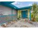 Charming front entrance with a colorful door and a tropical palm tree at 4544 Cynthia Ln, Spring Hill, FL 34606
