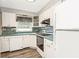 Bright kitchen featuring white cabinets, a sleek cooktop, and coordinated countertops at 4544 Cynthia Ln, Spring Hill, FL 34606