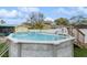 Backyard above-ground pool featuring a small deck and slide at 4544 Cynthia Ln, Spring Hill, FL 34606