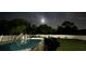 Outdoor pool featuring ladder, surrounded by green lawn and trees under the starry night sky at 4544 Cynthia Ln, Spring Hill, FL 34606