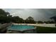 Backyard pool surrounded by lush greenery and rainbow creates a private and serene oasis at 4544 Cynthia Ln, Spring Hill, FL 34606