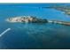 Aerial view of a peninsula featuring a sandy beach, boat, and bridge to the mainland at 494 Village Dr, Tarpon Springs, FL 34689
