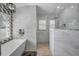 This bathroom features a soaking tub, shower, and white marble tiling at 494 Village Dr, Tarpon Springs, FL 34689
