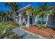 Inviting entrance with a blue door, elegant columns, and manicured landscaping at 494 Village Dr, Tarpon Springs, FL 34689