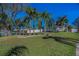A green front yard with several palm trees offers a view of a charming house at 494 Village Dr, Tarpon Springs, FL 34689