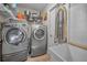 Well-equipped laundry room with side by side washer and dryer, shelving and utility sink at 494 Village Dr, Tarpon Springs, FL 34689