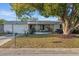 Charming single-story home featuring an attached garage and mature tree shading the front yard at 5039 Mecaslin Dr, New Port Richey, FL 34652