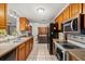 Functional kitchen featuring wood cabinets and neutral countertops, with an open view to dining room at 5039 Mecaslin Dr, New Port Richey, FL 34652