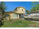 Exterior of yellow two-story home featuring boat on the side and a screened in entry porch at 5319 Ray Dr, Weeki Wachee, FL 34607