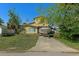 Exterior view of a two-story yellow house with a concrete driveway and a boat on a trailer at 5319 Ray Dr, Weeki Wachee, FL 34607