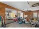 Spacious room with wood paneled walls, ceiling fan, and open access to adjacent room needing renovation at 5319 Ray Dr, Weeki Wachee, FL 34607