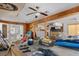 Living area needing renovation with an open concept layout, wood paneling, ceiling fans, and access to kitchen at 5319 Ray Dr, Weeki Wachee, FL 34607