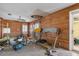 Living room with wood paneled walls, ceiling fan, and natural light, needing repair at 5319 Ray Dr, Weeki Wachee, FL 34607