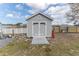 The backyard has a storage shed with a ramp and double doors, painted gray and trimmed in white at 6036 Dorset Rd, Spring Hill, FL 34608