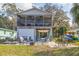 Home backyard featuring a patio with outdoor seating, garage, lush lawn, and a glimpse of the neighborhood canal at 6183 Waverly Rd, Weeki Wachee, FL 34607