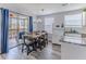Charming dining area features a wooden table, seating for six, a modern chandelier, and sliding door access to the balcony at 6183 Waverly Rd, Weeki Wachee, FL 34607