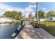 Waterfront property showcasing a private wooden dock with boat lift access to the serene canal and surrounding homes at 6183 Waverly Rd, Weeki Wachee, FL 34607