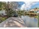 Waterfront home featuring a dock with a boat lift on a canal, surrounded by lush greenery and trees at 6183 Waverly Rd, Weeki Wachee, FL 34607