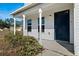 Welcoming front porch with white pillars and a modern blue front door at 6209 Radford St, Spring Hill, FL 34606