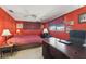 Cozy bedroom features bright red paint, a ceiling fan, and a spacious desk at 6627 Leeside Isle, Hudson, FL 34667