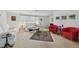Bright living room featuring neutral walls and carpet, with white sofas, red chairs and area rug at 6627 Leeside Isle, Hudson, FL 34667