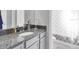 Well-lit bathroom with a granite countertop, a decorative mirror, and tiled shower at 6741 Citrus Creek Ln, Tampa, FL 33625