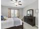 Comfortable bedroom featuring a ceiling fan, a large dresser with mirror, and lots of natural light at 6741 Citrus Creek Ln, Tampa, FL 33625