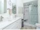 Bright bathroom featuring double sinks, white cabinets, and a glass-enclosed shower with marble tile at 700 S Harbour Island Blvd # 807, Tampa, FL 33602