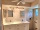 Bathroom with double vanity, granite countertops, a shower, and custom lighting at 7106 Green Abbey Way, Spring Hill, FL 34606