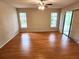 Bright bedroom with wood flooring, ceiling fan, and a large sliding glass door at 7106 Green Abbey Way, Spring Hill, FL 34606