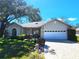 Charming single-story home featuring stone accents, a two-car garage, a skylight, and a paved driveway at 7106 Green Abbey Way, Spring Hill, FL 34606