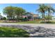 Elegant community center entrance with vibrant flower beds, mature trees, and a welcoming canopy at 7106 Green Abbey Way, Spring Hill, FL 34606