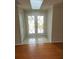 Bright foyer with double doors featuring decorative glass, tile floor, a skylight, and hardwood floors at 7106 Green Abbey Way, Spring Hill, FL 34606