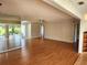 Large living room with hard wood floors and a mirrored wall to make the room feel even more spacious at 7106 Green Abbey Way, Spring Hill, FL 34606