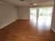 Spacious living room featuring hardwood floors and a sliding glass door leading to the backyard at 7106 Green Abbey Way, Spring Hill, FL 34606