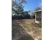 Backyard of the property with patchy grass and some trees at 7278 Lamplighter St, Spring Hill, FL 34606