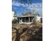 Exterior view of the home's screened patio and overgrown backyard at 7278 Lamplighter St, Spring Hill, FL 34606