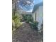 A view of the house showing the side yard with dense vegetation and an overgrown area at 7278 Lamplighter St, Spring Hill, FL 34606