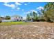 Spacious backyard with green grass, partial fence, trees, and an above ground pool at 9291 Geranium Ave, Spring Hill, FL 34606