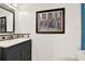 Elegant bathroom with a stylish vanity, framed art, and a well-lit mirror at 9291 Geranium Ave, Spring Hill, FL 34606