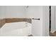 Clean, white bathtub with a tiled backsplash and minimalist hardware at 9291 Geranium Ave, Spring Hill, FL 34606