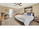 Cozy bedroom with neutral walls, soft carpet, king bed, and an adjacent sitting area at 9291 Geranium Ave, Spring Hill, FL 34606