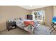 Sunny bedroom with large window, ceiling fan, carpeted floor, and neutral wall color at 9291 Geranium Ave, Spring Hill, FL 34606