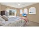 Well-lit bedroom featuring a ceiling fan, large window with a view, and three arched niches at 9291 Geranium Ave, Spring Hill, FL 34606